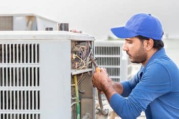 A,Professional,Electrician,Man,Is,Fixing,The,Heavy,Air,Conditioner