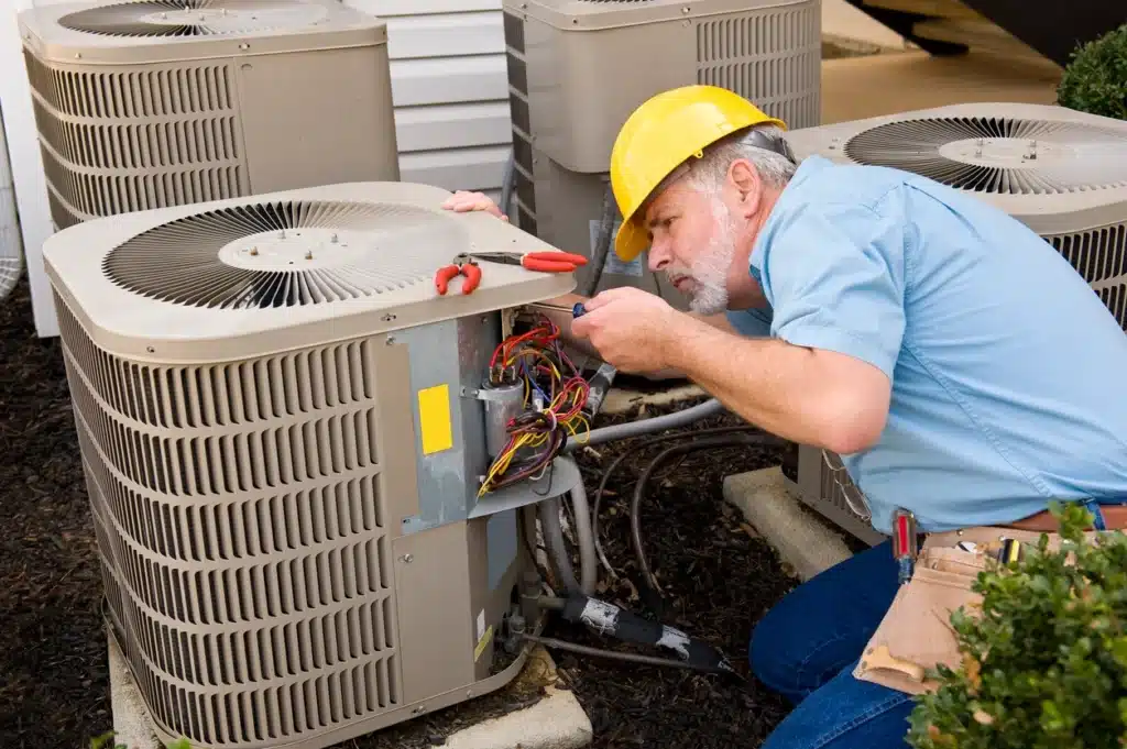 A technician is focused on servicing an air conditioner