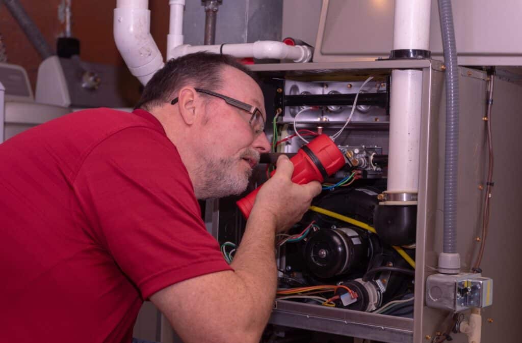 A technician inspecting the furnace unit