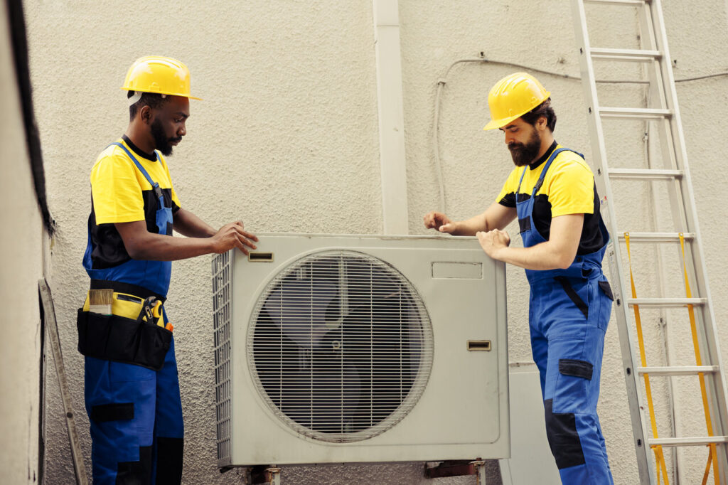 HVAC technicians are working on AC unit